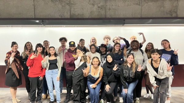 Group of ASU students posing for a photo and making the pitchfork symbol with their hands.