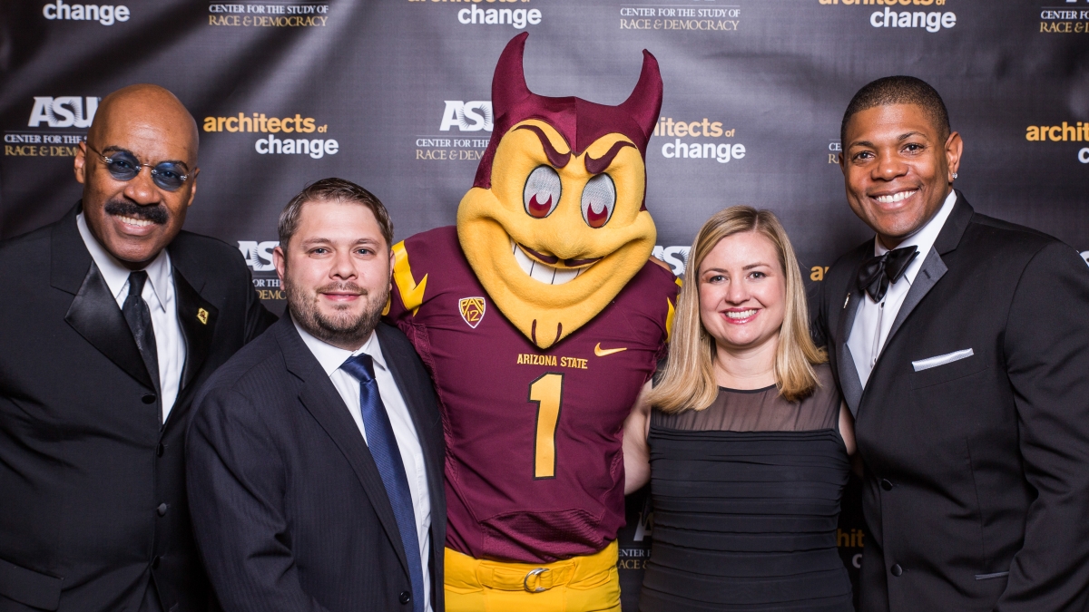 group of people pose with Sparky the Sun Devil at a gala event