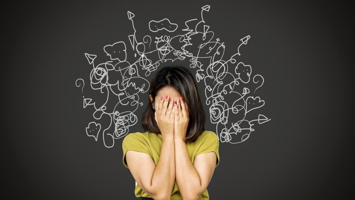 Stock photo of woman with head in hands and stress drawings displayed around her