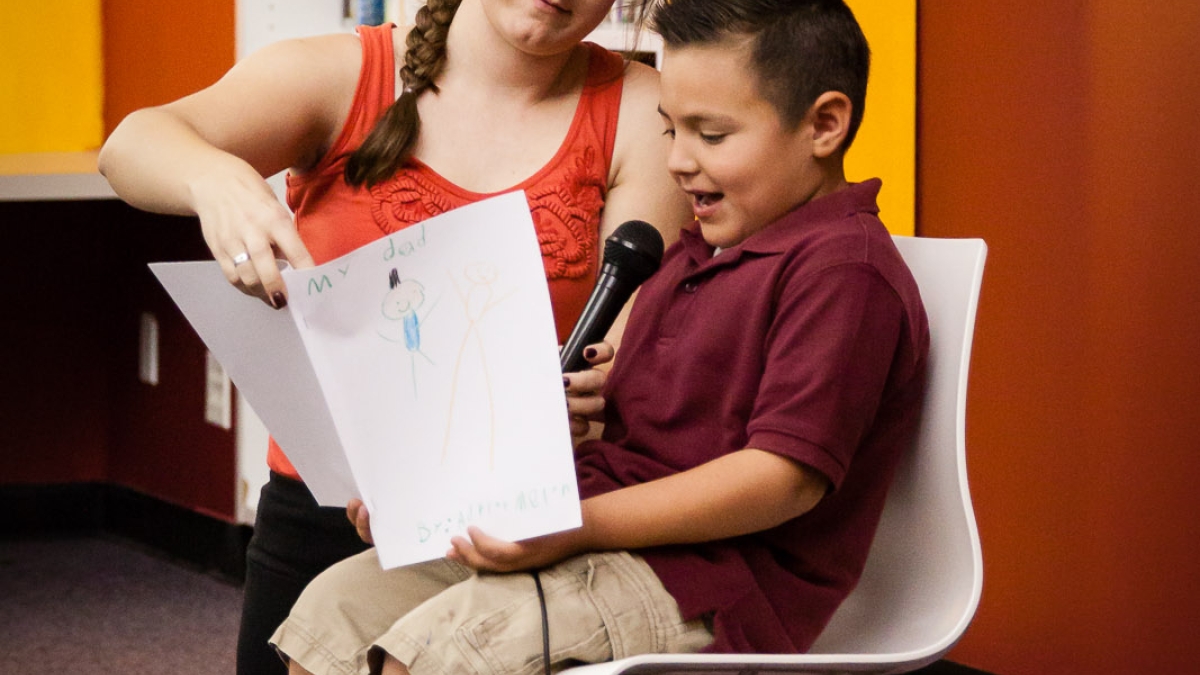 teacher Gini Jackson helping a student read aloud