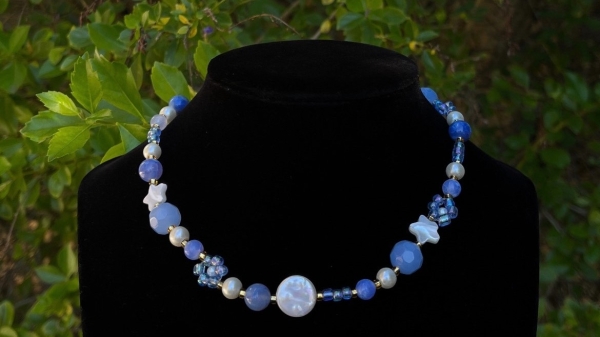Necklace of blue stones shown against a black background