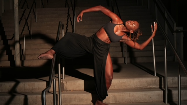 A dancer poses on stairs