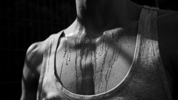 black and white close-up of person's chest with sweat on it