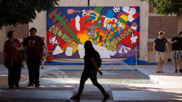 Students walk past the Hispanic Heritage mural.