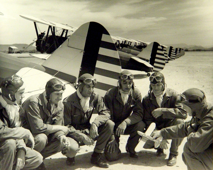 Group of pilots surrounding airplane