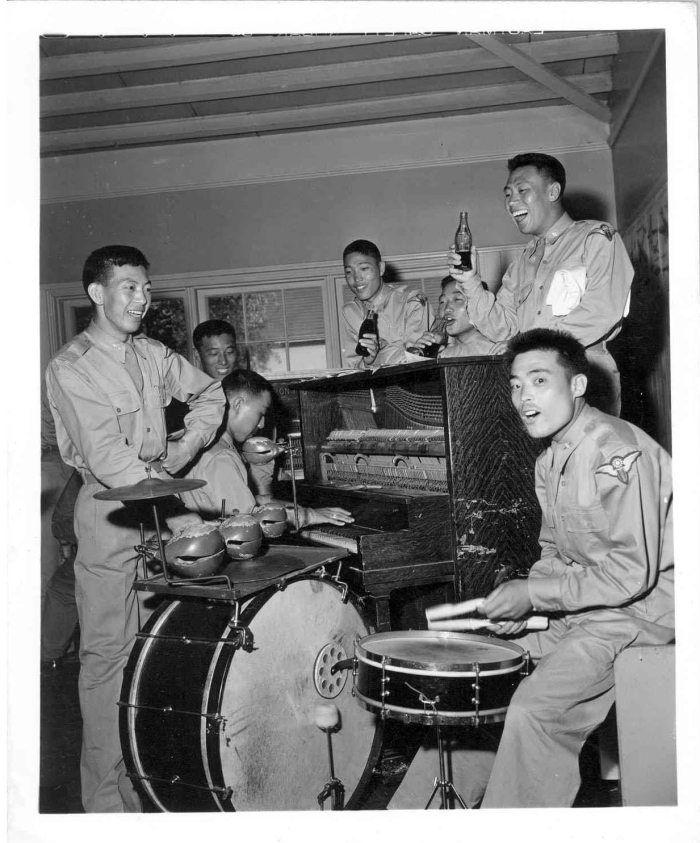 Group of Chinese men around a piano